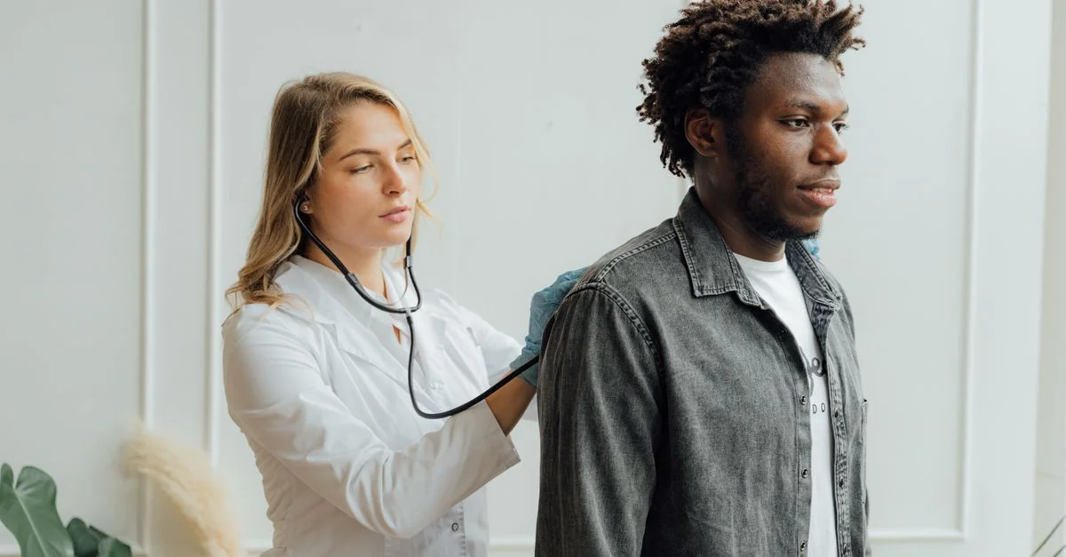 Médecin effectuant un examen sur un patient avec un stéthoscope à l'intérieur.