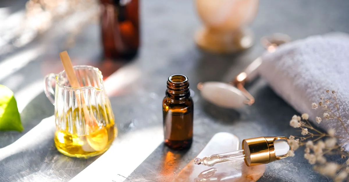 Huiles aromatiques et outils de spa disposés sur une table, parfaits pour la relaxation.